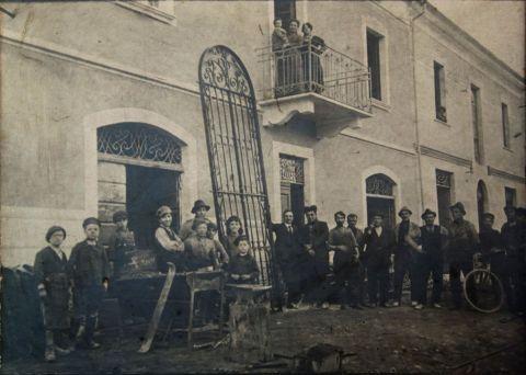 La vecchia sede produttiva, oggi adibita a sala mostra. Al centro (settimo da destra) Romolo Montanelli, il fondatore della ditta. In primo piano, dietro l'incudine, il figlio Trento. Accanto la forgia con una lega destinata al consolidamento di una casa interessata dal forte terremoto che colpì la Garfagnana in quegli anni. Appoggiato alla parete il cancello di una villa storica di Bagni di Lucca, anni venti