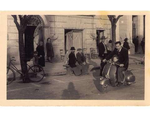 Luigi Ghelfi in vespa col figlio davanti al negozio, 1951