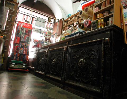 Particolare del pregiato bancone in legno di noce nazionale scolpito. Costituiva la parte frontale di un palco del Teatro Chiabrera di Savona e fu acquistato da Gioacchino Fava (bisnonno dell’attuale proprietario) intorno al 1890
