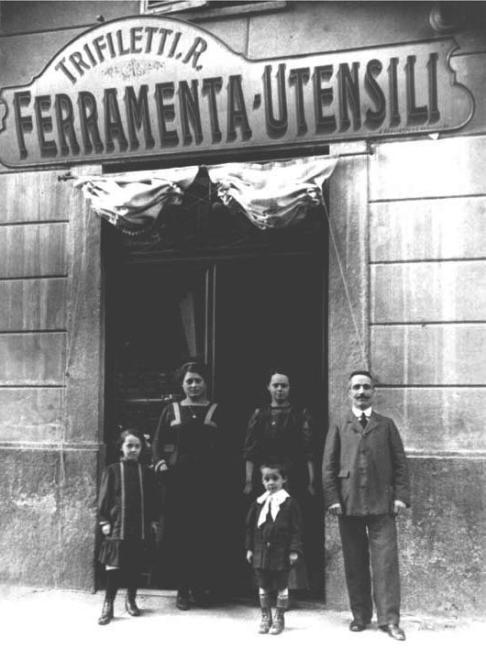 Sulla soglia del negozio a sinistra Carmelo Trifiletti con al suo fianco la moglie Rosa e il piccolo Giovanni, primi anni '10