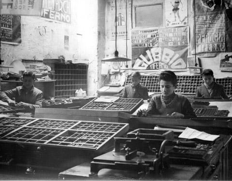 Gli allievi della Scuola di Avviamento Professionale per le Arti Grafiche durante un'esercitazione di composizione a mano alla Grifani Donati (1941)