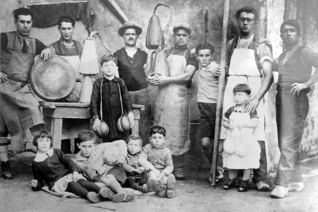 I casari e i garzoni ritratti nella latteria di Codisotto di Luzzara con i rispettivi figli. Seduti a terra il padre e gli zii di Andrea Bertoni, fine anni Venti del Novecento