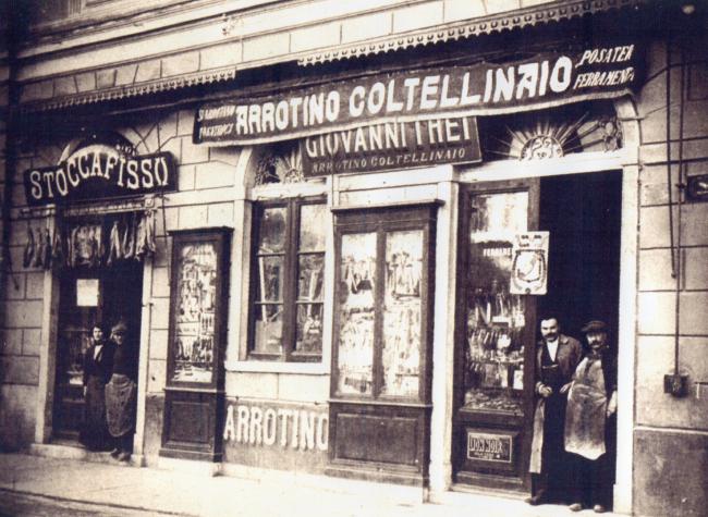 Giovanni They, a sinistra, sulla porta del negozio, anni Venti del Novecento