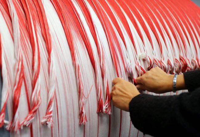 Reparto produttivo: ordito, filati, mani meticolose al lavoro, 2014