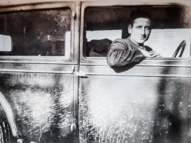 Bruno Paparella alla guida di un'autovettura utilizzata come taxi nell'immediato dopoguerra
