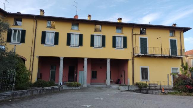 Il porticato del condominio attuale: ristrutturato negli anni Duemila, con la realizzazione di unità abitative, è sede sociale e panificio della cooperativa, 2024