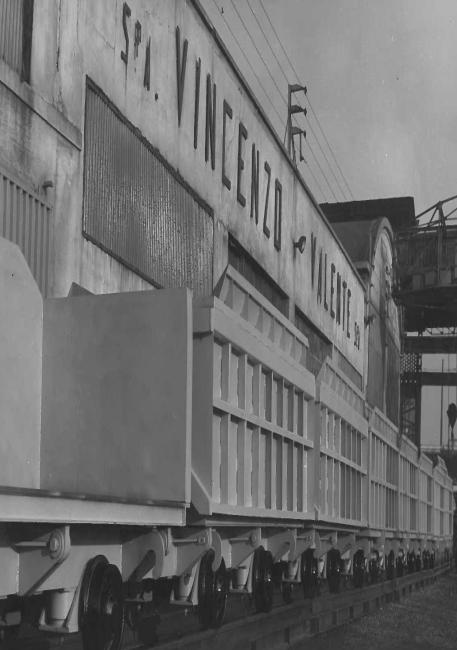 Esterno dello stabilimento Vincenzo Valente, con in primo piano vagoni da smarino (vagoni per il trasporto di materiale da scavo in sotterraneo), 1960