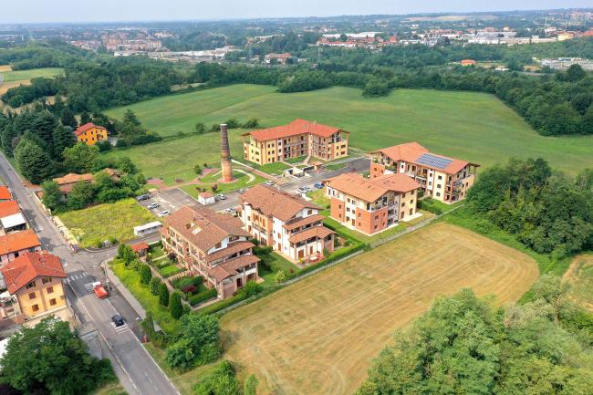 La Residenza Antica Fornace a Carnate. L’intervento di ristrutturazione ha mantenuto l’antica ciminiera a memoria dell’originario sedime di fornace. Anni  Dieci del Duemila