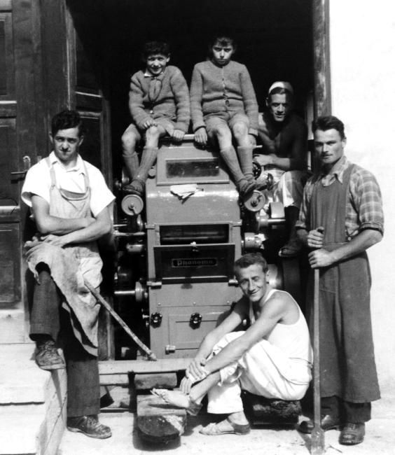 Alcuni operai ritratti con un macchinario d'epoca, anni Cinquanta