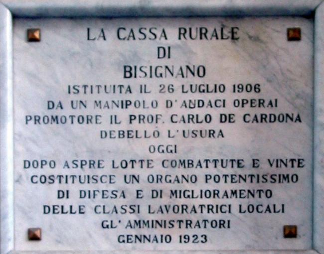 La targa in marmo, posta dinanzi alla filiale di Bisignano nel 1923, a ricordo della fondazione del 1906